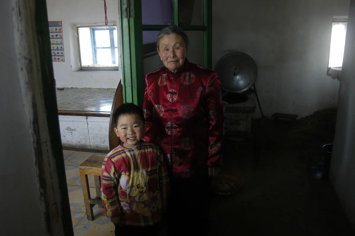Meng Shujing (82) with grandson Shi Junguang (30) and great-grandson Shi Yaobin (5) at home in Sanjiazi near the town of Qiqihar in Heilongjiang province in North-east China. 2007