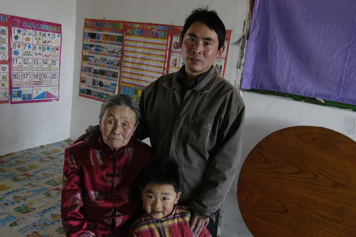 Meng Shujing (82) with grandson Shi Junguang (30) and great-grandson Shi Yaobin (5) at home in Sanjiazi near the town of Qiqihar in Heilongjiang province in North-east China. 2007
