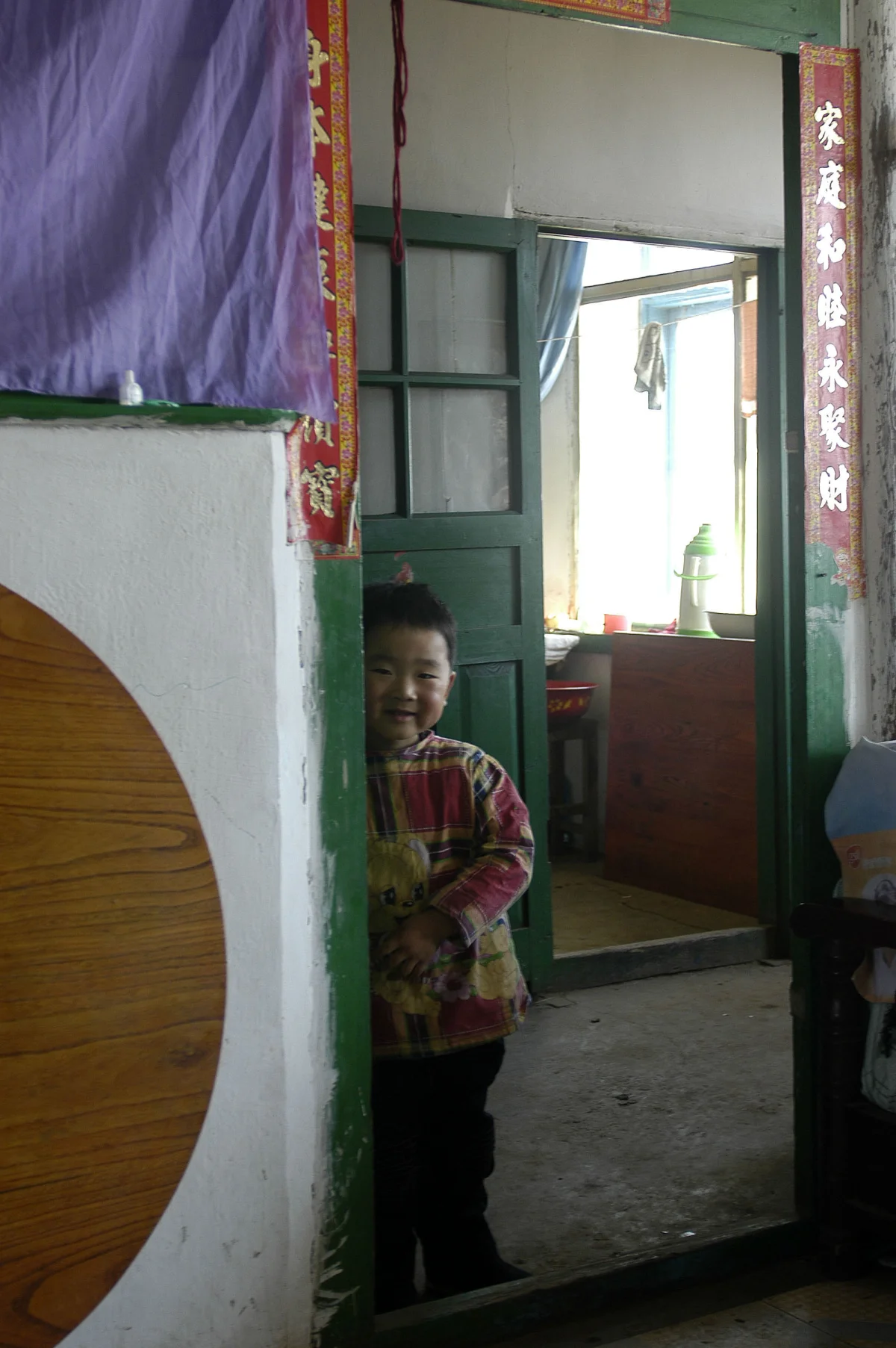 Meng Shujing (82) with grandson Shi Junguang (30) and great-grandson Shi Yaobin (5) at home in Sanjiazi near the town of Qiqihar in Heilongjiang province in North-east China. 2007