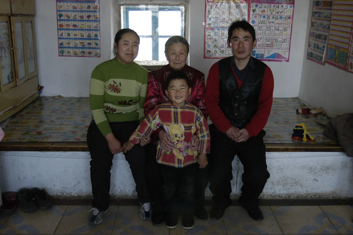 Meng Shujing (82) with grandson Shi Junguang (30), his wife Dai Ai Li (27) and their son Shi Yaobin (5) at home in Sanjiazi near the town of Qiqihar in Heilongjiang province in North-east China, 2007.